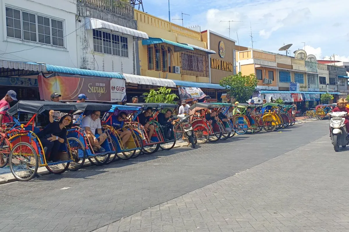 Foreign tourists enjoy pedicab tours on Batam's Behindpadang Island